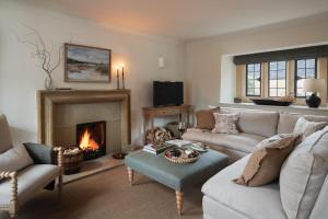 a living room with a couch and a fireplace at The Little Barn in Lower Slaughter