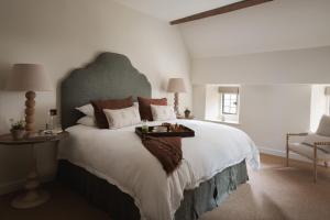 a bedroom with a large bed with a tray on it at The Little Barn in Lower Slaughter