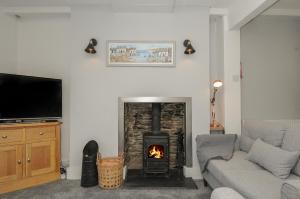 ein Wohnzimmer mit einem Kamin und einem Sofa in der Unterkunft Farleigh Cottage in Looe