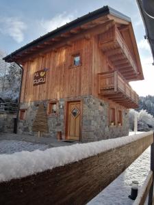 a log cabin in the winter with snow on the ground at Chalet Al Cucù in Ovaro