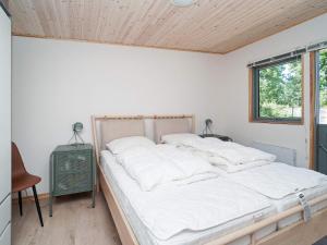 een slaapkamer met een bed met witte lakens en een raam bij 5 person holiday home in Eskebjerg in Eskebjerg