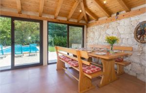 a dining room with a table and a stone wall at Lovely Home In Kucice in Kučiće