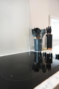 a kitchen counter with a black counter top with utensils at Morden house close to City centre & The Peaks in Chesterfield