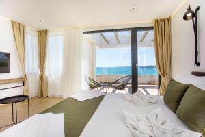 Schlafzimmer mit einem Bett und Meerblick in der Unterkunft Olive Villas Beach Hotel in Sozopol