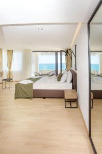 a bedroom with a large bed and a view of the ocean at Olive Villas Beach Hotel in Sozopol