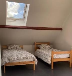 two beds in a room with a window at Peyranère in Urdos