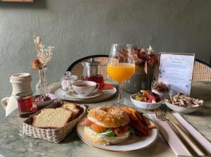 a table with a sandwich and a glass of orange juice at La maison du tripot in Honfleur