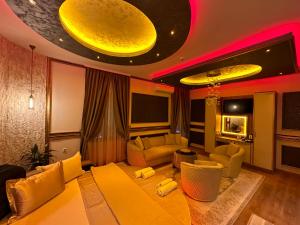 a living room with a large yellow couch and chairs at Robevski luxury rooms in Bitola