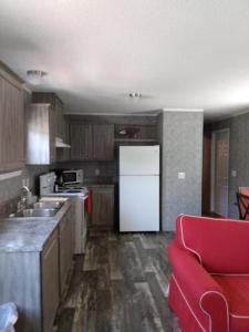 a kitchen with a white refrigerator and a red couch at Lake Point Motel in Marblehead