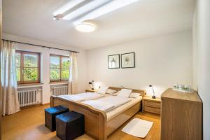 1 dormitorio con 1 cama y 2 taburetes en Klausenhansenhof en Wolfach