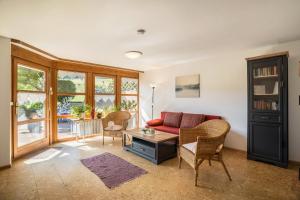 沃爾法赫的住宿－克勞森坦森霍夫公寓，客厅配有红色的沙发和椅子