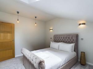 a bedroom with a large white bed with a couch at The Hideout King Bed/w TV Free Parking in Cheltenham