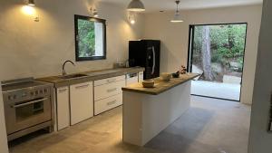 a kitchen with a counter with a sink and a refrigerator at Villa Bel Air in Saint-Côme