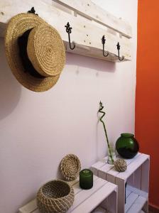 un sombrero de paja colgando de una pared con jarrones en Los Caños de La Casa Viva, en Vélez Blanco