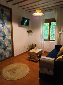 Los Caños de La Casa Viva في فيليز بلانكو: غرفة معيشة مع أريكة وطاولة