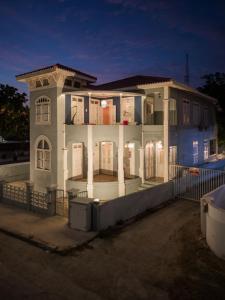a large white house with columns and a fence at Villa Amalie & Villa Curiel in Willemstad