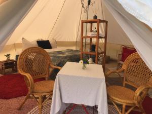 a room with a table and chairs and a tent at Helles Have Glamping in Stege