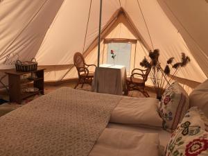 a tent with a bed and a table and chairs at Helles Have Glamping in Stege