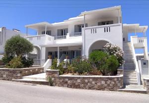 a large white house with stairs and plants at Marianos Apartments in Antiparos