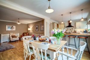 uma cozinha e sala de estar com uma mesa de madeira e cadeiras em Manor Road em Stratford-upon-Avon