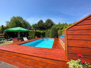 a swimming pool with a wooden fence around it at ZEFIR Dąbki in Dąbki