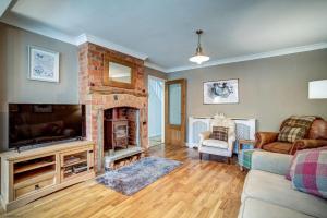 a living room with a fireplace and a television at Manor Road in Stratford-upon-Avon