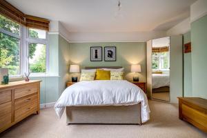 um quarto com uma cama grande e 2 janelas em Manor Road em Stratford-upon-Avon