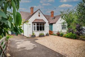 a white house with a driveway in front of it at Manor Road in Stratford-upon-Avon