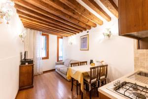 eine Küche und ein Wohnzimmer mit einem Tisch und einem Sofa in der Unterkunft Ca' Pinelli in Venedig
