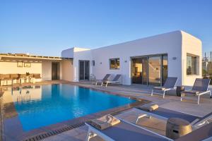 a villa with a swimming pool and a patio at Villa j-view in Psarou