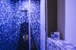 baño con ducha con azulejos azules en la pared en Serendipity Rooms en Milán