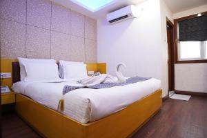 um quarto com uma cama grande e um cisne em Hotel Emirates em Calcutá