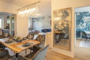 comedor y sala de estar con mesa de comedor y espejo en SweetHome - DAH02 - LUXUS PUR Apartment, Küche, TV en Dachau