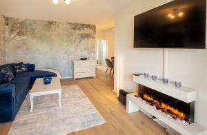 a living room with a blue couch and a fireplace at SweetHome - DAH02 - LUXUS PUR Apartment, Küche, TV in Dachau