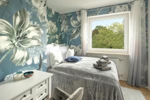 a bedroom with a bed with a flower wallpaper at SweetHome - DAH02 - LUXUS PUR Apartment, Küche, TV in Dachau