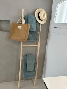 a towel ladder with a hat and a chair at Cosy2stay Moncayo Golf Apartememt in Altea la Vieja