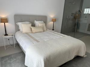 sypialnia z dużym łóżkiem z białą pościelą i poduszkami w obiekcie Cosy2stay Moncayo Golf Apartememt w mieście Altea la Vieja