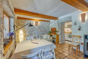 kuchnia i salon ze stołem w obiekcie Holiday House Mlin w mieście Kras