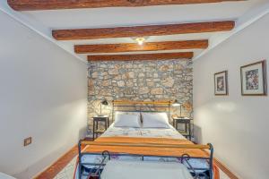 sypialnia z łóżkiem i kamienną ścianą w obiekcie Holiday House Mlin w mieście Kras +27 zdjęć