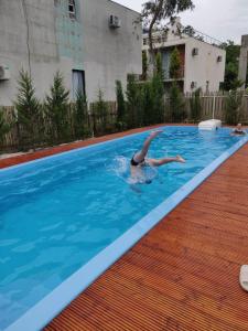 a person is swimming in a swimming pool at Cottages in Kaprovani "Family nest" in Ureki