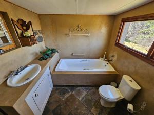 ein Badezimmer mit Badewanne, Toilette und Waschbecken in der Unterkunft Stone Cottage in Dullstroom + 30 Fotos
