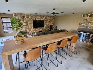 einen großen Holztisch im Wohnzimmer mit Stühlen in der Unterkunft Stone Cottage in Dullstroom