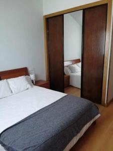 1 dormitorio con 1 cama grande y espejo en Casa do Cervo - San Cibrao, en San Ciprián