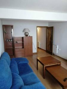 a living room with a blue couch and a table at Casa do Cervo - San Cibrao in San Ciprián