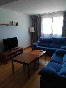 Sala de estar con sofás azules y mesa de centro en Casa do Cervo - San Cibrao, en San Ciprián