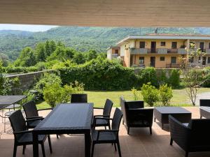 d'une terrasse avec tables et chaises et vue sur une maison. dans l'établissement Villa Lori, à Fornaci di Barga