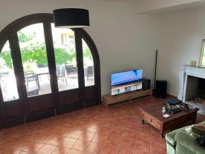 sala de estar con puerta, TV y sofá en Villa Lori, en Fornaci di Barga