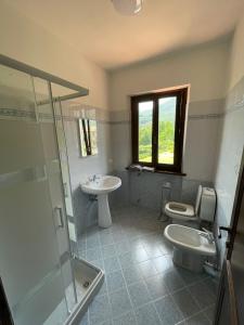 y baño con lavabo, aseo y ducha. en Villa Lori, en Fornaci di Barga