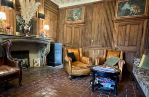 uma sala de estar com duas cadeiras e uma lareira em Les Glycines Vézelay em Vézelay