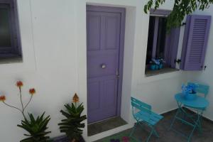 a purple door in a room with a table and chairs at Vourkari Studio in Gialiskari